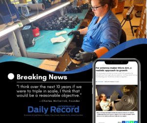 Graphic with person in the background in blue shirt sitting at a desk with mechanical parts. Text Reads: "Breaking News. "I think over the next 10 years if we were to triple in scale, I think that would be a reasonable objective". attributed to Charles McCarrick, Founder. Below reads "Jacksonville Daily Record, Business & legal news in Baker, Clay, Duval, Nassau & St. Johns Counties" Image of cell phone to right with article about Micro-Ant.